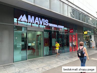 Exterior view of Mavis Tutorial Centre storefront with people walking by.
