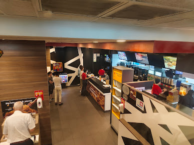 Interior view of a McDonald's restaurant with customers, staff, and service counters.