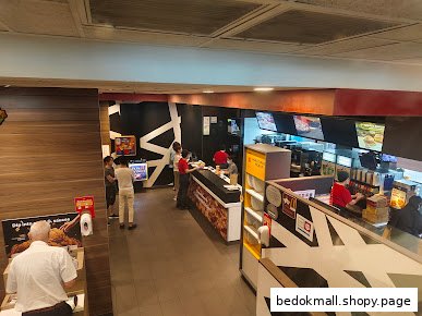 Interior view of a McDonald's restaurant with customers, staff, and service counters.