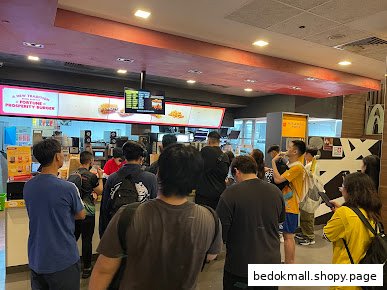 Customers queueing at the counter inside a busy fast-food restaurant.