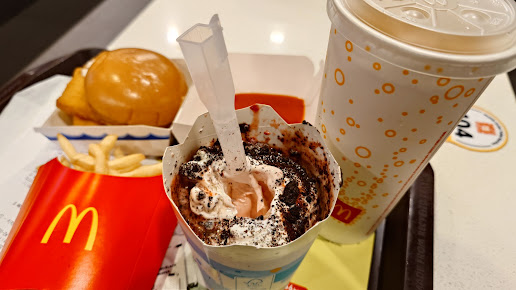 A McDonald's meal with fries, burger, drink, and a chocolate dessert on a tray.
