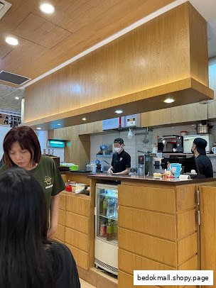 Interior view of a shop counter with staff and customers.