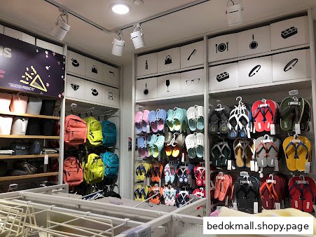 Interior view of a retail shop displaying various products like bags and footwear.