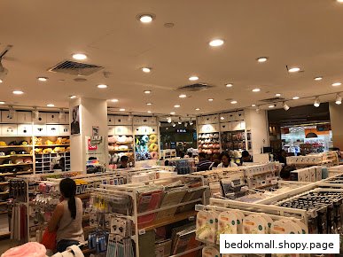 Interior view of a MINISO store with various products and customers browsing.