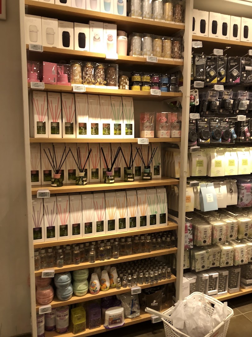 Shelves filled with diffusers, candles, and various household products inside a retail shop.