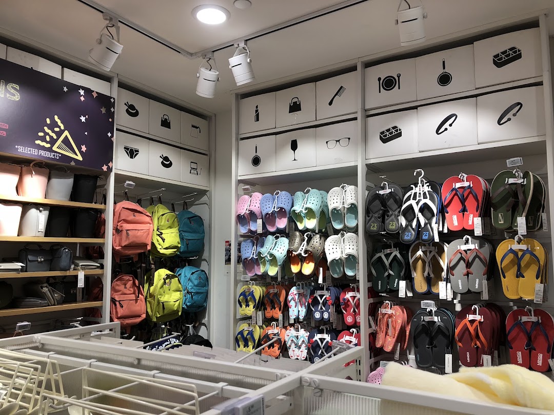 Interior view of a retail shop displaying bags, backpacks, and footwear.