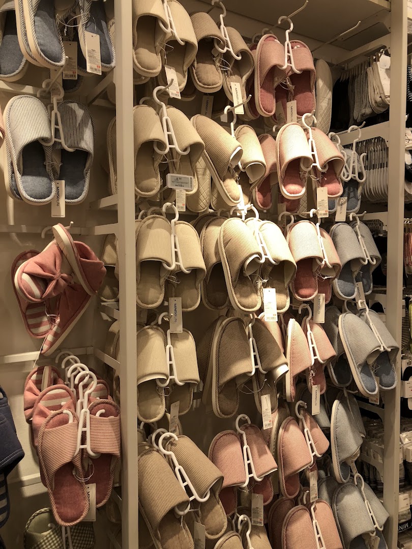 Numerous slippers displayed on racks inside a retail store.