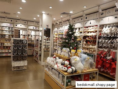 Interior view of a MINISO store with products and a Christmas tree.