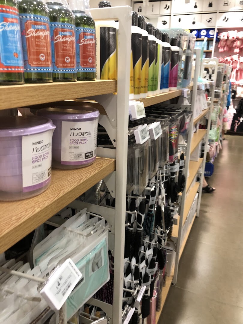Shelves stocked with various products like shampoo and hairbrushes inside a retail shop.