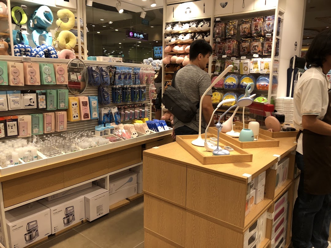 Interior view of a MINISO store with products on shelves and customers browsing.