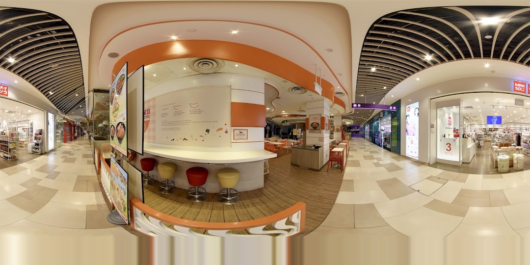 Shopping mall interior with a MINISO store and a food stall area.