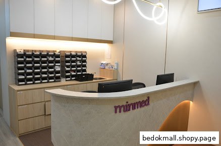Interior view of a clinic reception desk with monitors and storage.