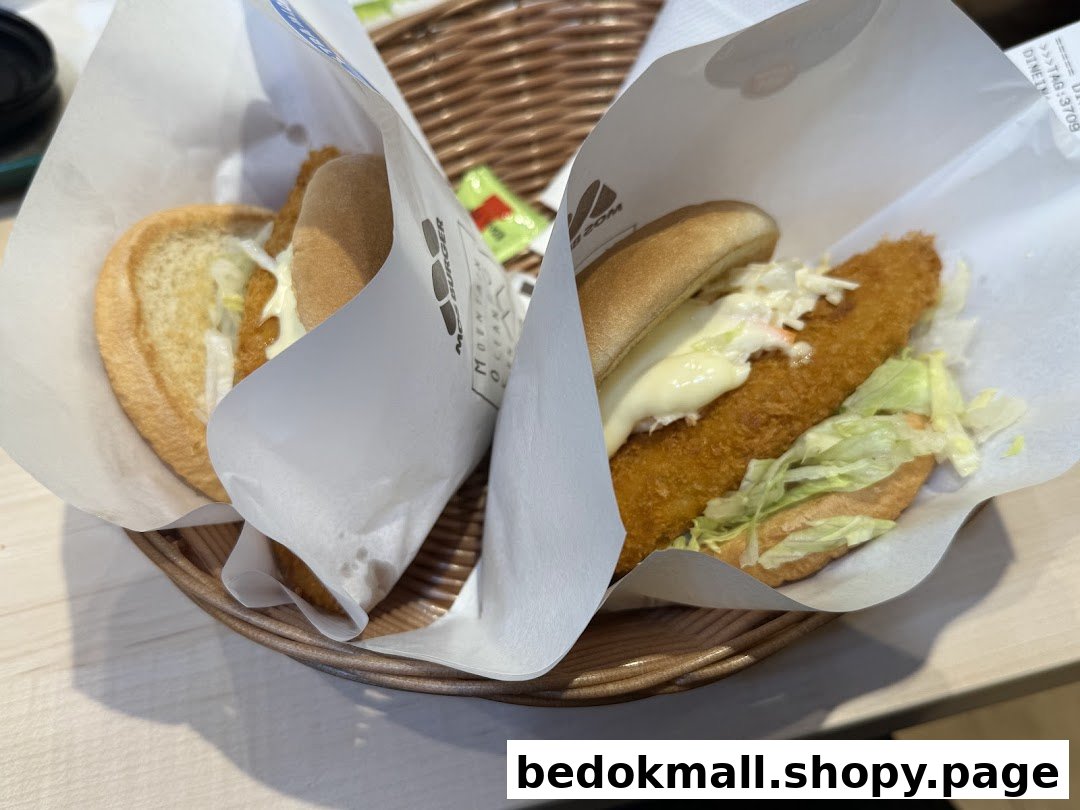 Two burgers in paper wrappers are served in a wicker basket.