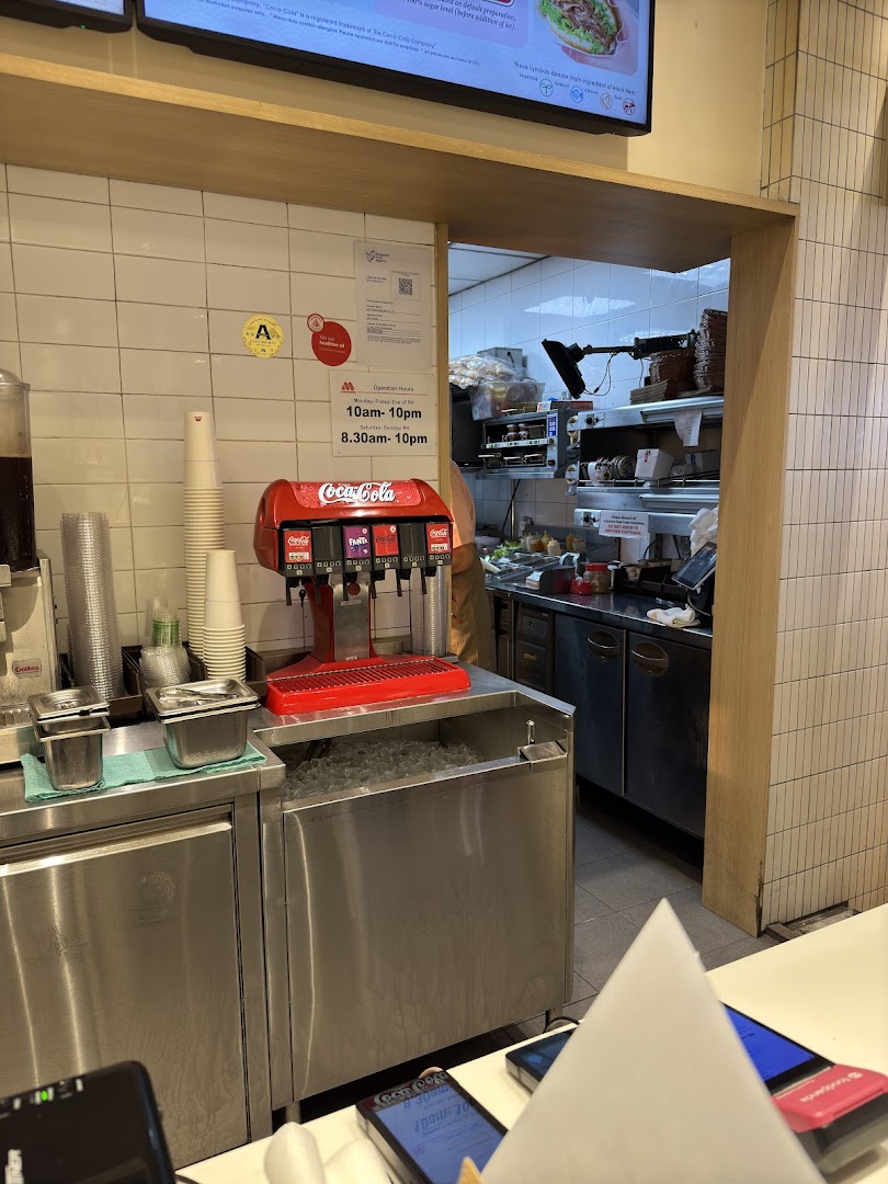 Interior view of a fast-food restaurant with a soda fountain and kitchen visible.