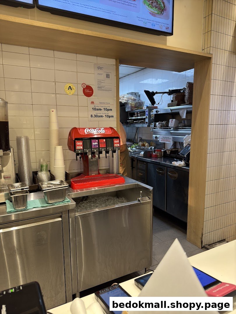 Interior view of a fast-food restaurant with a soda fountain and kitchen visible.
