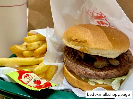 A burger, fries, drink, and chili sauce on a tray.