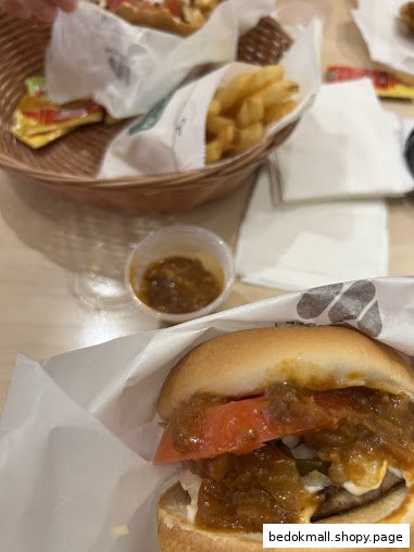 A burger, fries, and sauce on a table at MOS Burger.