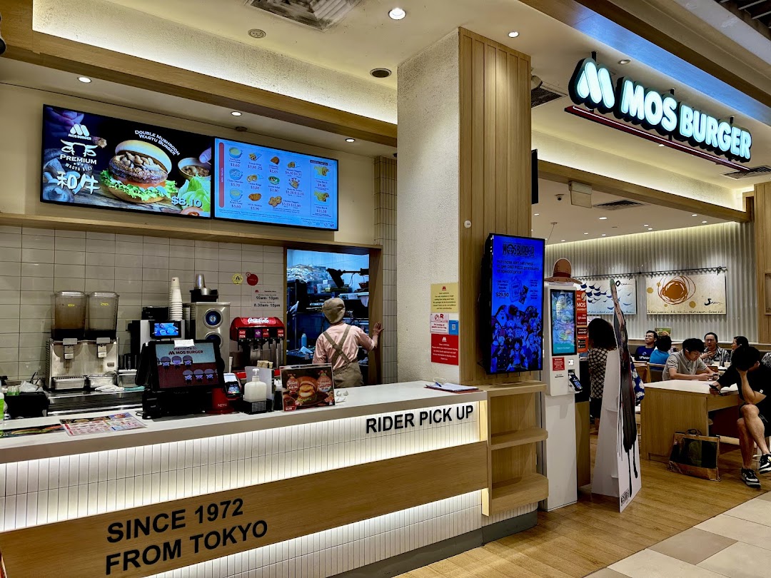 Interior view of a MOS Burger restaurant with counter, staff, and customers.