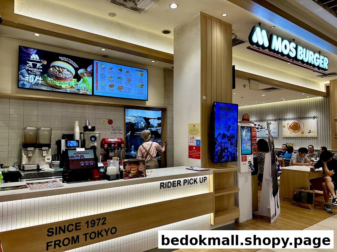 Interior view of a MOS Burger restaurant with counter, staff, and customers.