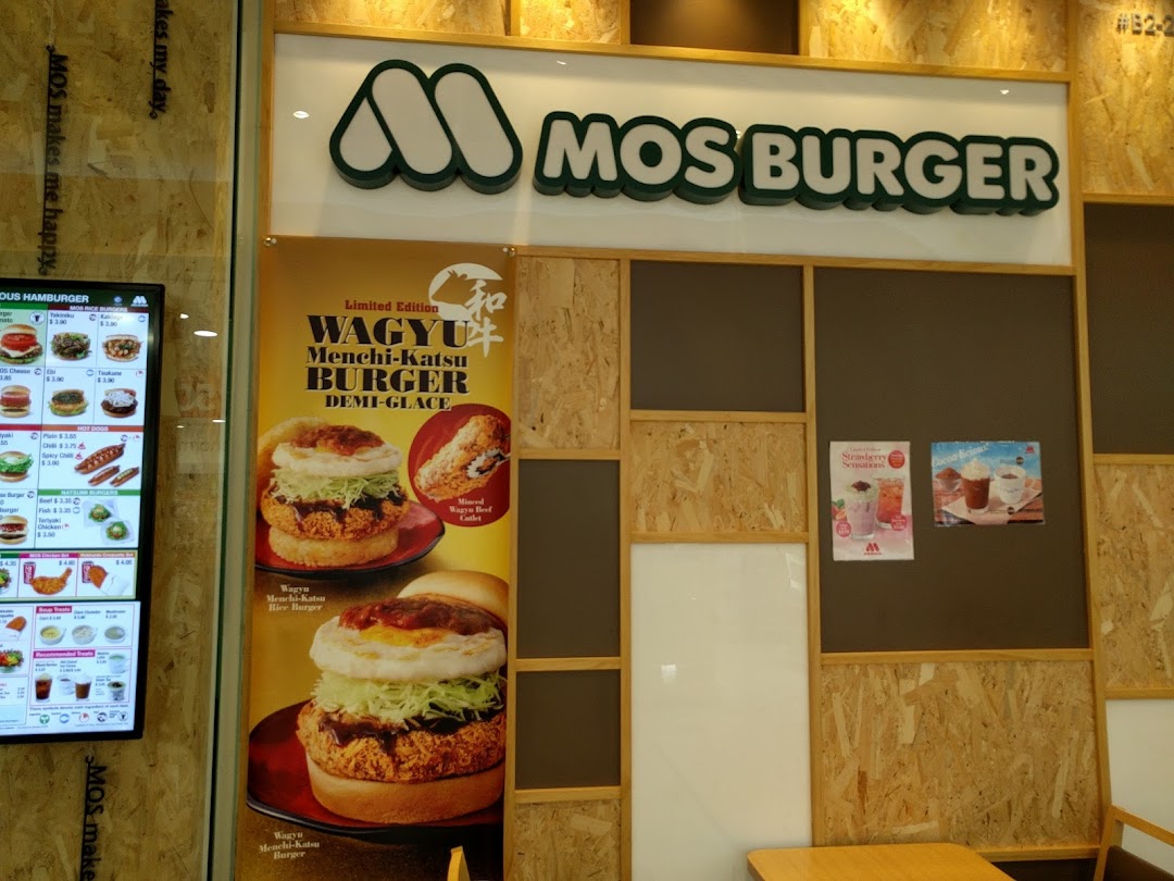 Interior view of MOS Burger with branding, promotional poster, and digital menu.
