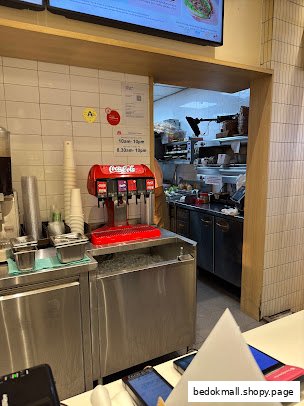 Interior view of a fast-food restaurant showing a soda fountain and kitchen.
