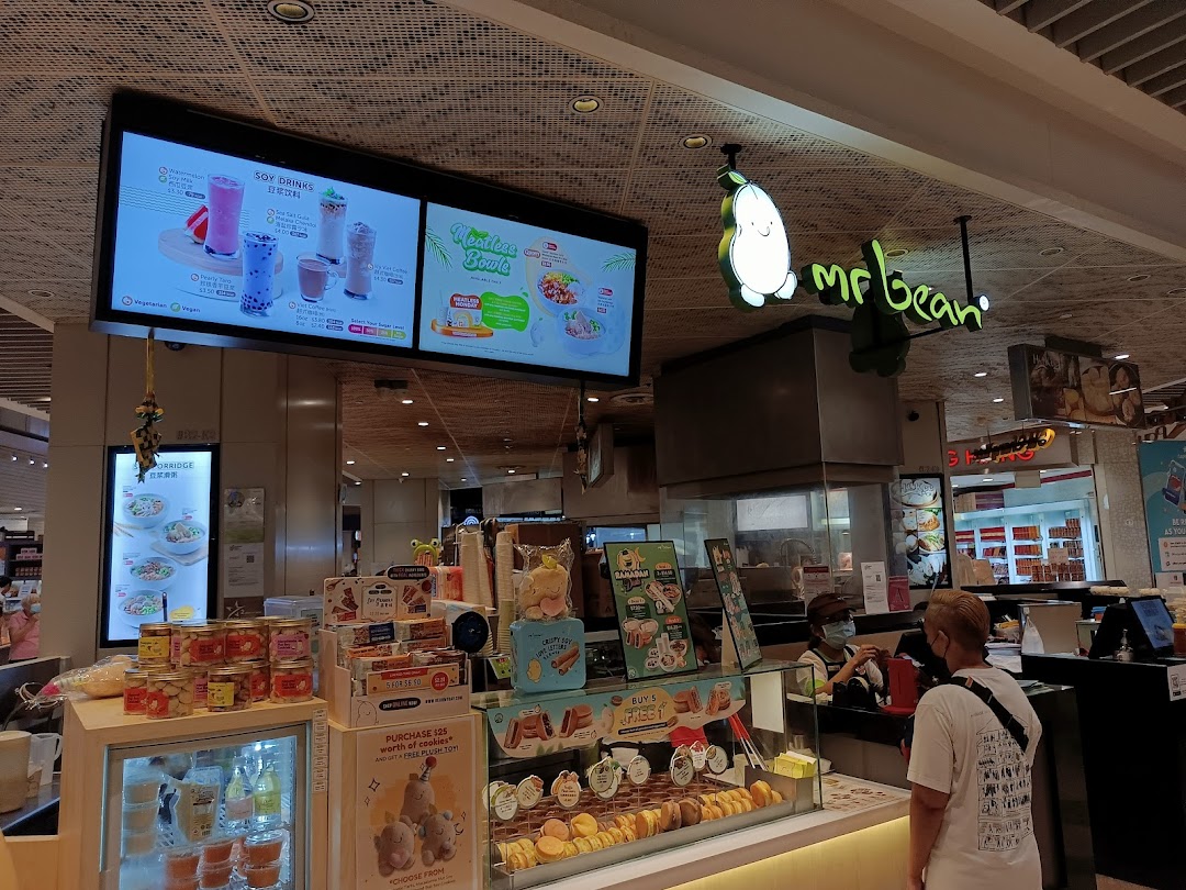 Interior view of a Mr Bean shop with counter, products, and digital menus.