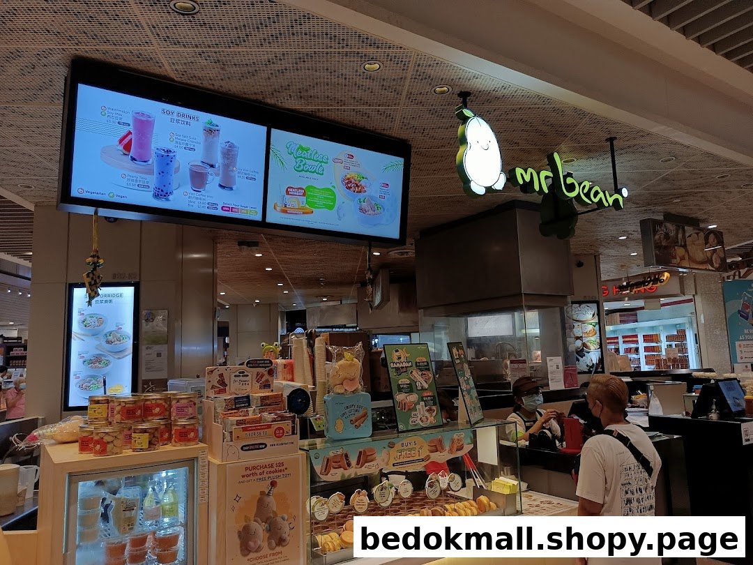 Interior view of a Mr Bean shop with counter, products, and digital menus.