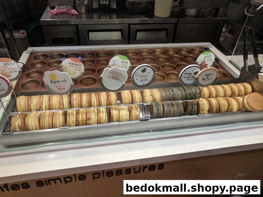 Display of freshly made round pastries with various fillings and price tags.