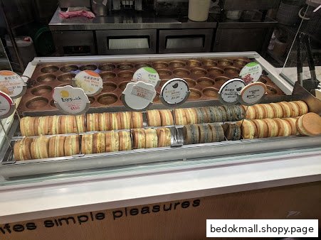 Display case with various pancakes and price tags in a food shop.