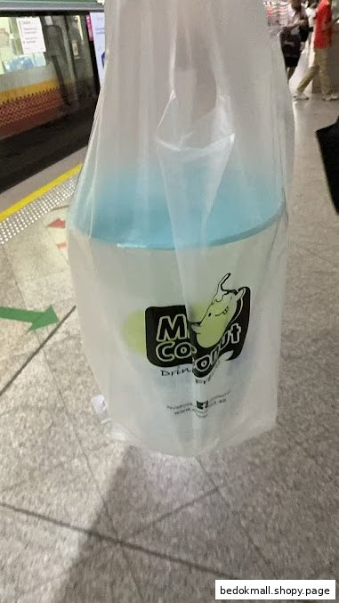 A Mr. Coconut drink cup in a plastic bag on a tiled floor.