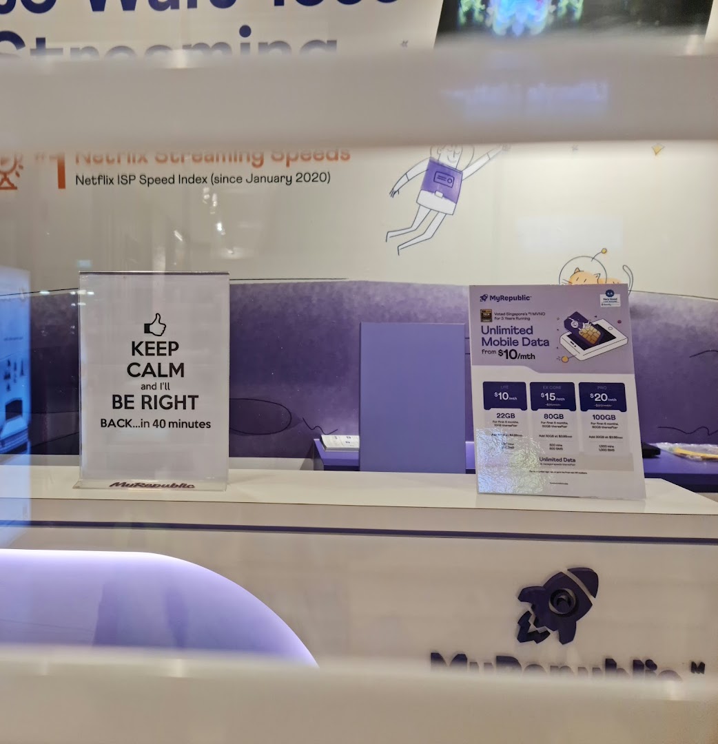Shop counter displaying mobile data plans and a 'be right back' sign.