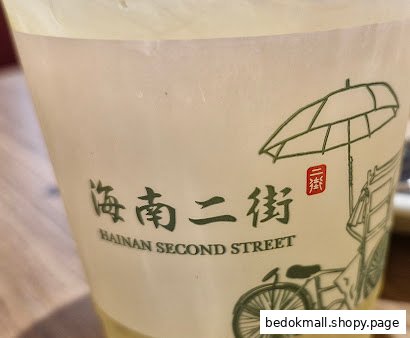 Close-up of a cup with 'Hainan Second Street' logo and rickshaw illustration.