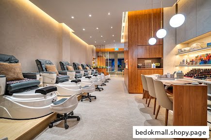 Interior view of a modern nail salon with pedicure chairs and manicure stations.