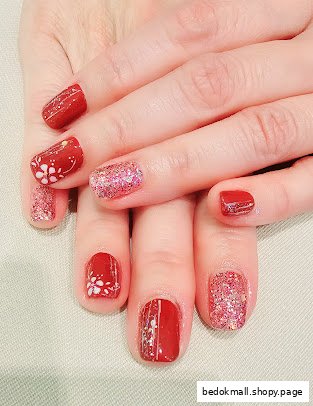 Close-up of hands with red and glitter manicured nails.