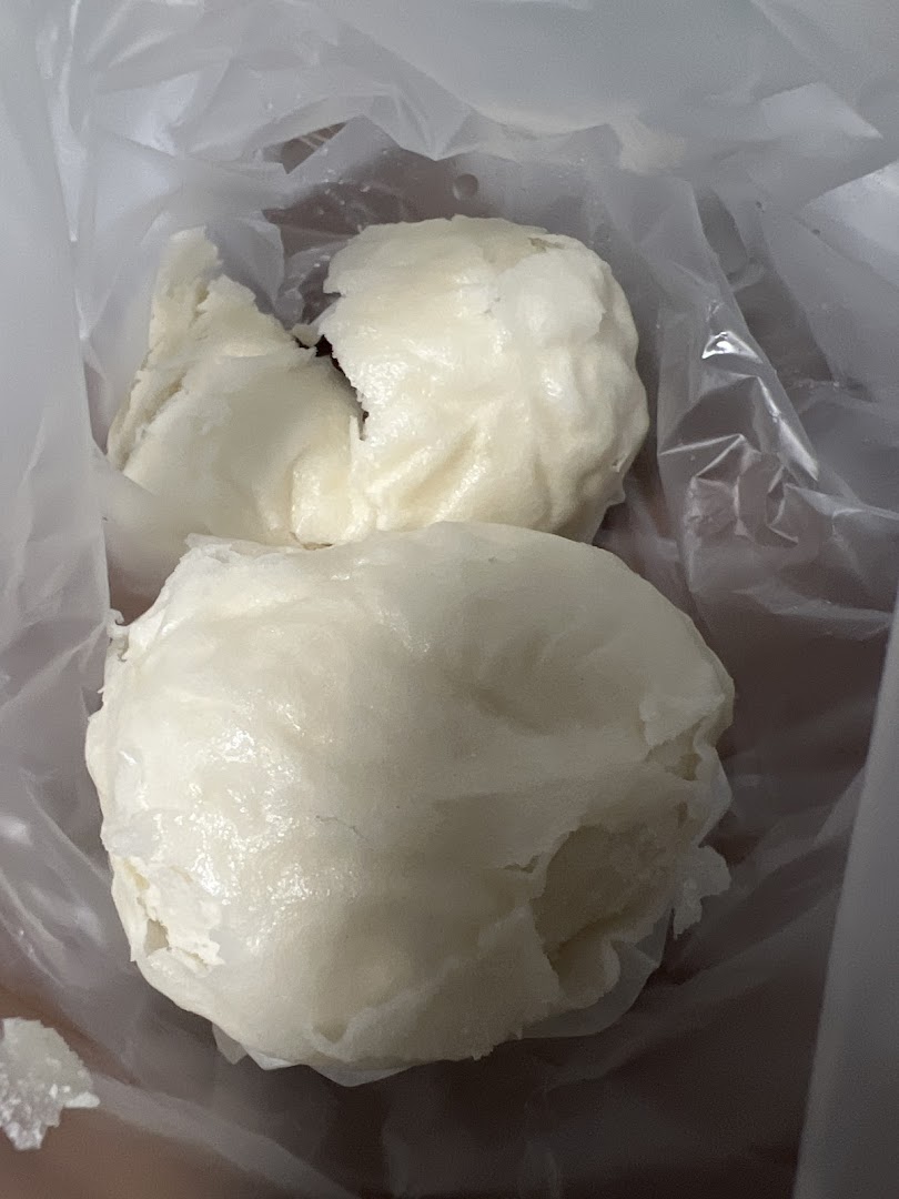 Two white buns or pau in a clear plastic bag.