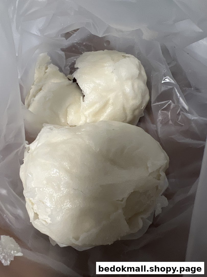 Two white buns or pau in a clear plastic bag.