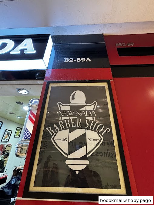 Entrance of New Nada Barber Shop with logo, barber pole, and unit numbers.