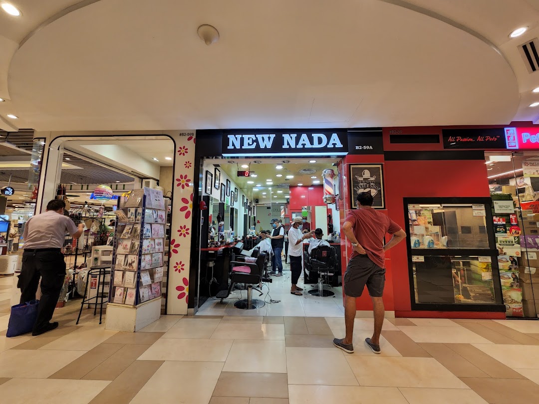 Entrance of a barber shop in a mall with people inside and outside.