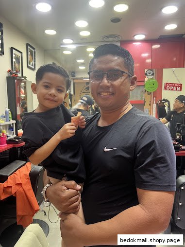 Adult and child smiling inside a barber shop.