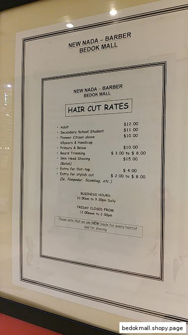 Sign displaying hair cut rates and business hours for New Nada Barber.