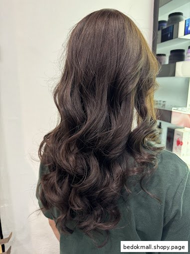 Long wavy dark hair from behind, likely in a hair salon setting.