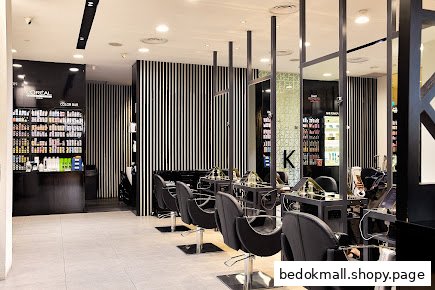 Interior of a modern hair salon with styling chairs and product displays.