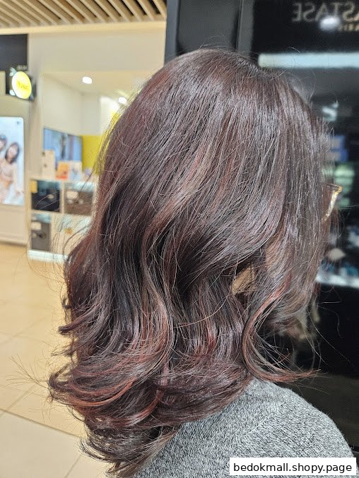 Close-up of a person's styled and colored hair from behind.