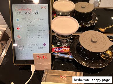 Tablet displaying refreshment menu with drinks and snacks on a table.