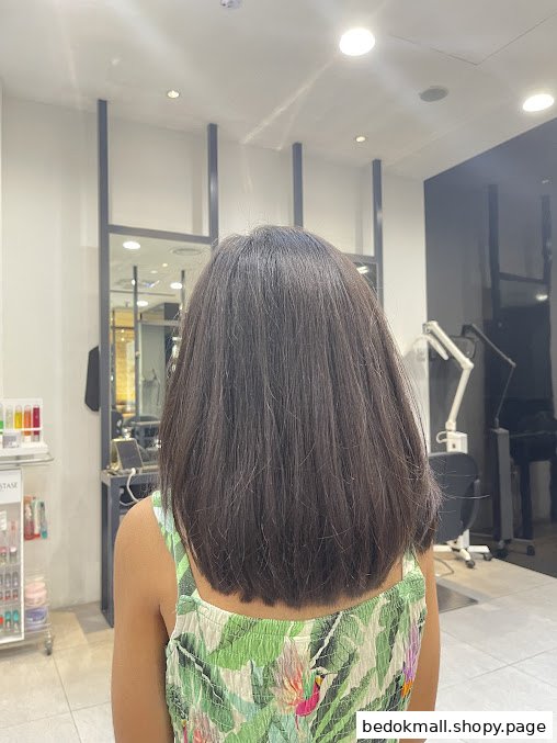 Back of person with long hair in a hair salon interior.