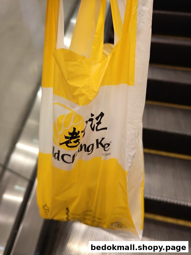 A yellow and white Old Chang Kee plastic bag on an escalator.