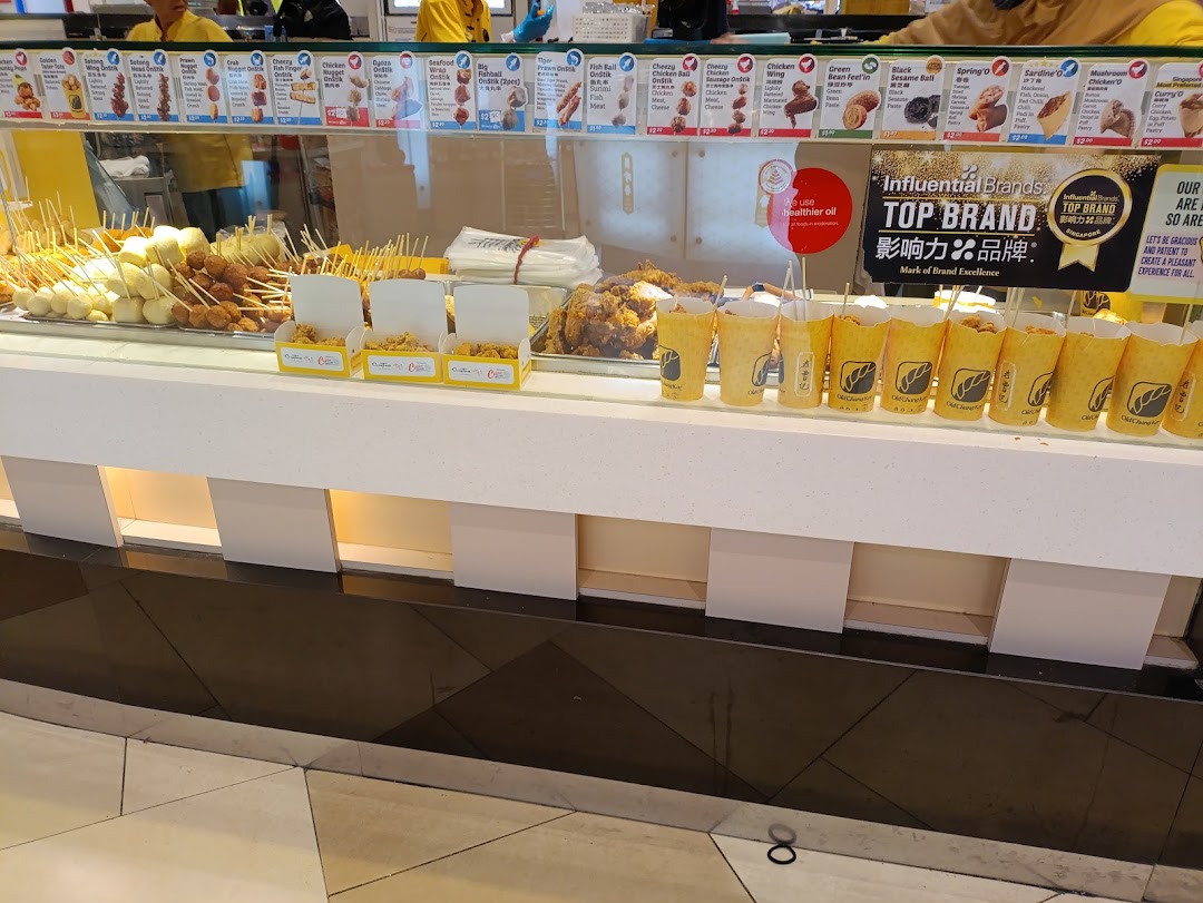 Display counter of a food stall with various fried snacks and menus.