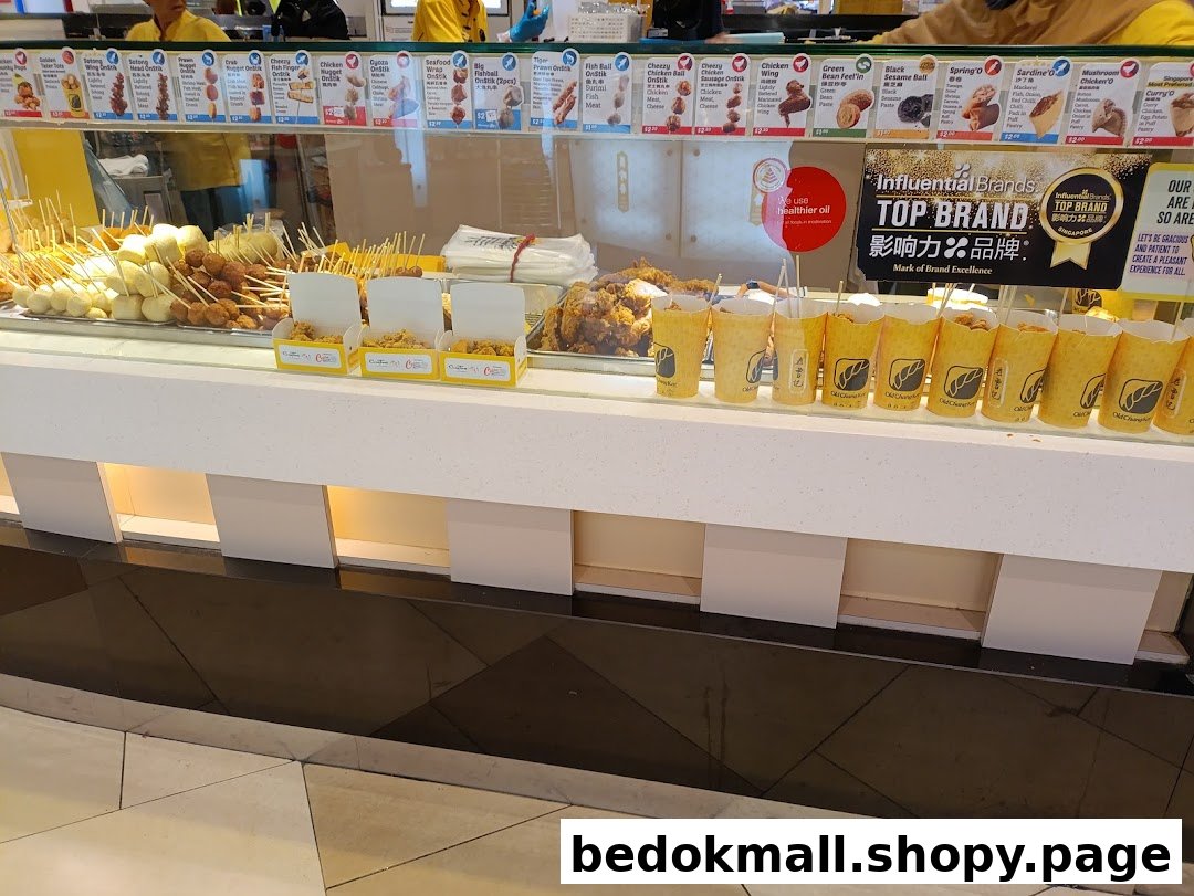 Display counter of a food stall with various fried snacks and menus.
