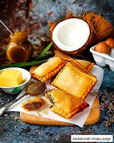 Golden pastries with ingredients like coconut, eggs, and butter on a wooden board.