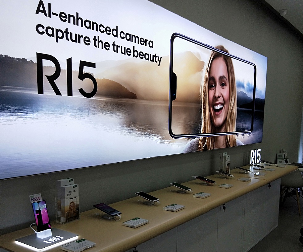 Interior shot of a phone store with display models and a large promotional banner.